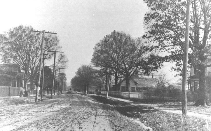 Early dirt road through Piedmont with homes and power poles